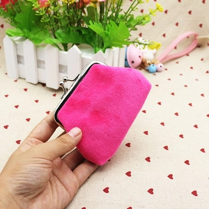 Close-up of a small rose pink plush coin purse with a metal kiss-lock clasp held in hand