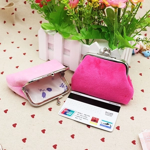 Close-up of plush coin purses in pink with metal clasps and floral lining