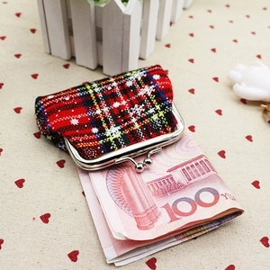 Detail of red plaid fabric coin purse showing internal capacity with a bank note