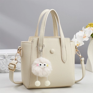 Minimalist cream white lychee leather handbag with furry charm and adjustable strap