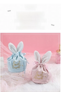 Close-up of blue and pink velvet rabbit ear candy bags with Sweet Moment gold text