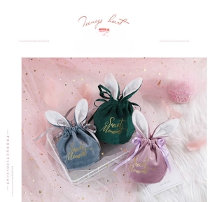 Detailed close-up of rabbit ear velvet favor bags with gold Sweet Moment printing