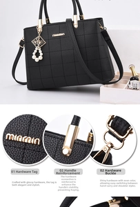 Detail view of the pearl pendant and golden hardware on the embroidered black handbag