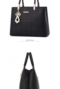 Detail of black tote bag with checkered embossing and pearl pendant accessory