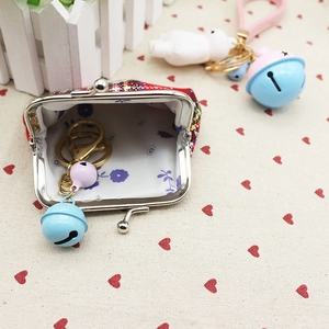 Close-up of red plaid mini coin purse with metal clasp and floral fabric lining