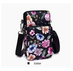 Detail view of mini floral crossbody phone bag with double zippers and black nylon strap