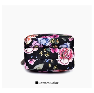Bottom view of a floral mini crossbody bag showing triple zipper layer design