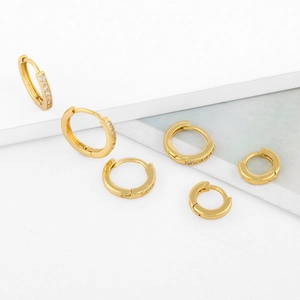 Detailed comparison of various sizes and styles of gold huggie earrings with zircons