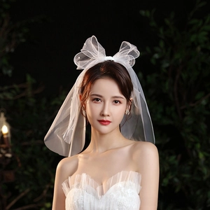Detail of white bridal mesh hair bow featuring scattered pearl accents and elegant double layers