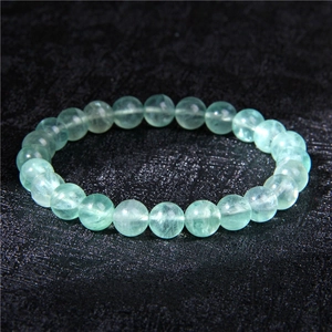 Macro shot of 8mm translucent green natural stone beads with smooth polished texture
