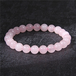 Macro detail of 8mm rose quartz beaded bracelet showing natural stone texture and polish