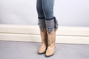 Close-up of bohemian knit leg warmers with blue and white jacquard waves and tassels