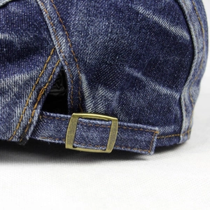 Detailed macro view of the vintage denim beret featuring an adjustable copper metal buckle