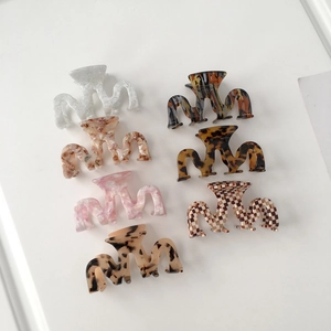 Set of seven M-shaped acetate hair claws in marble and tortoiseshell patterns
