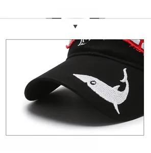 Detail of embroidered shark and Island text on washed black cotton baseball cap