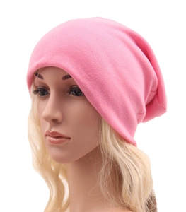 Dettaglio del berretto in maglia rosa che mostra la consistenza morbida del cotone