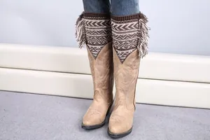 Detail of knitted leg warmers with bohemian fringe and jacquard patterns on western boots
