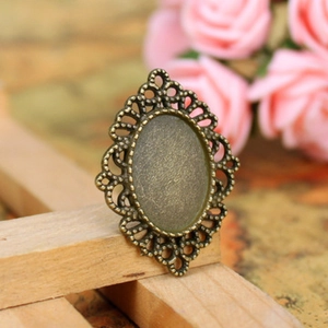 Detailed close-up of antique bronze olive branch pendant with filigree hollow design