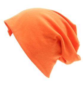 Dettaglio del berretto in cotone lavorato a maglia arancione con drappeggio morbido su bianco