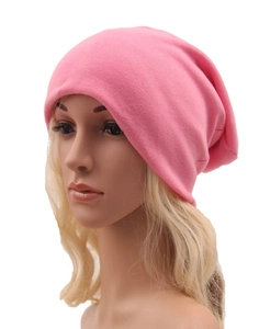 Dettaglio ravvicinato di un berretto in maglia rosa con texture morbida su una testa