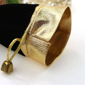 Macro shot of black velvet jewelry pouch with golden metallic trim and drawstring detail