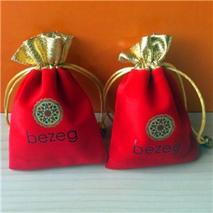 Detail showing two red velvet jewelry pouches with gold drawstrings and bezeg logo
