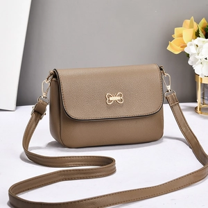 Sac bandoulière minimaliste en cuir marron avec fermoir doré et détail de fleurs fraîches