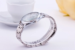 Close-up of silver steel watch with Roman numerals and classic metal link bracelet