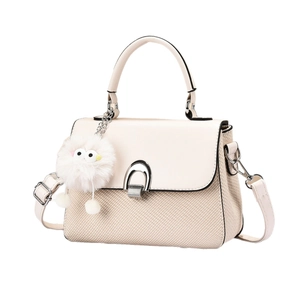Chic beige crossbody handbag with woven texture and cute plush charm on white background