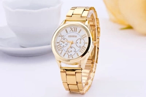 Detail of a Geneva gold-tone steel watch featuring a white dial and Roman numerals
