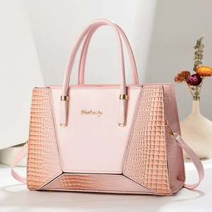 Vue détaillée du sac à main rose avec texture crocodile élégante et logo doré brillant