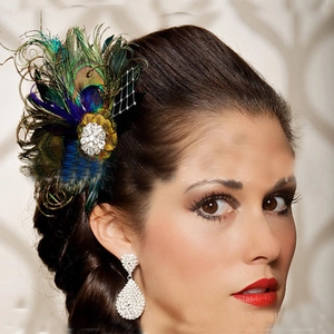 Close-up of elegant peacock feather hairclip with sparkling rhinestones and black mesh veil
