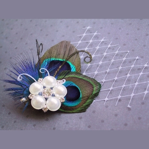 Detail of peacock feathers, white pearls, and rhinestones on mesh bridal headpiece