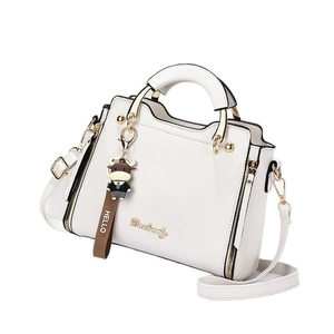 Elegant white faux leather handbag with golden logo and brown cartoon cow keychain charm