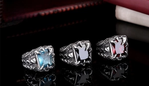 Macro shot of gothic dragon claw rings with emerald-cut zirconia in blue, red, and black