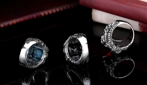 Macro shot of vintage dragon claw rings with square zircon insets and engraved textures