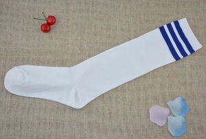 Detail of white cotton knee-high socks with blue triple stripes on a rustic linen background
