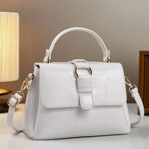 Close-up of white crocodile pattern leather texture with golden metal hardware detail