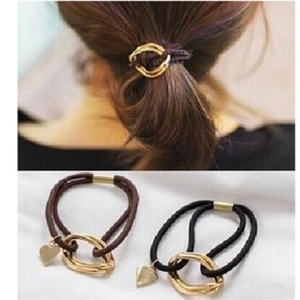 Detail of brown and black elastic hair ties with gold metal rings and heart pendants