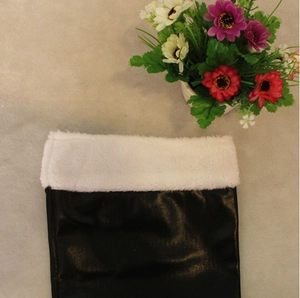 Detailed view of Santa boots with black leather finish and short plush white trim accent
