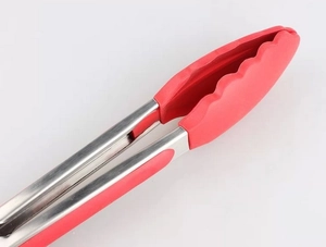 Détail des embouts en silicone rouge avec bords festonnés sur la pince de cuisine