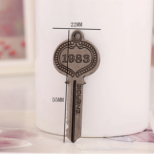 Macro shot of bronze vintage key pendant with 1983 and Energie embossed text details