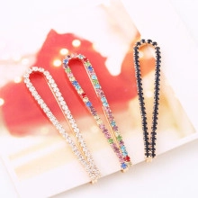 Detailed shot of three rhinestone hair clips in gold and black finishes with crystals