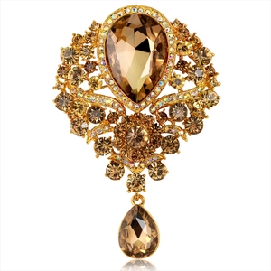 Detailed view of a vintage gold alloy brooch with champagne teardrop glass pendants