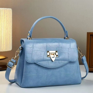 Light blue faux crocodile handbag with gold triangular buckle and adjustable strap