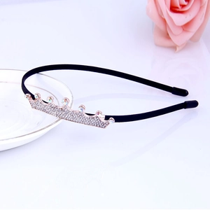 Close-up of a black headband featuring a gold crown set with sparkling rhinestones