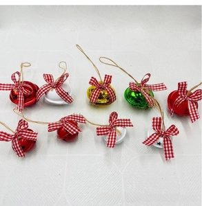 Set of colorful metal Christmas bells with plaid bows and rustic jute ropes for hanging