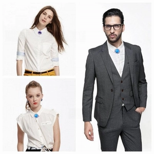 Close-up of a lucky rabbit blue gem lapel pin on a white shirt and gray suit jacket