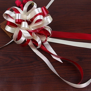 Top view of a large bicolor red and beige ribbon bow for gift and car decoration