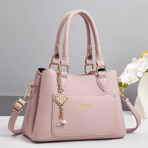Pink lychee grain leather handbag with gold metal charm and adjustable shoulder strap